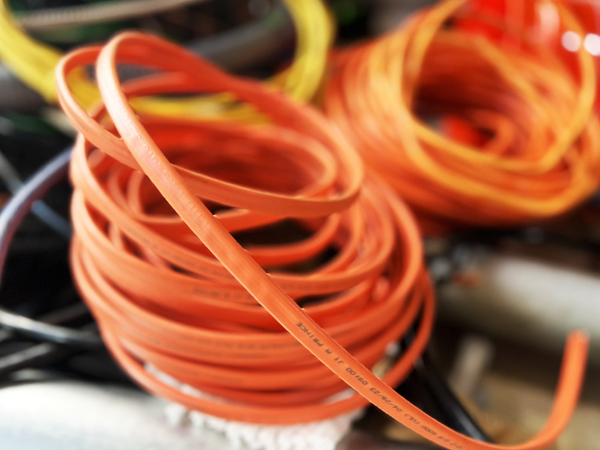 A photo of orange electric wires.