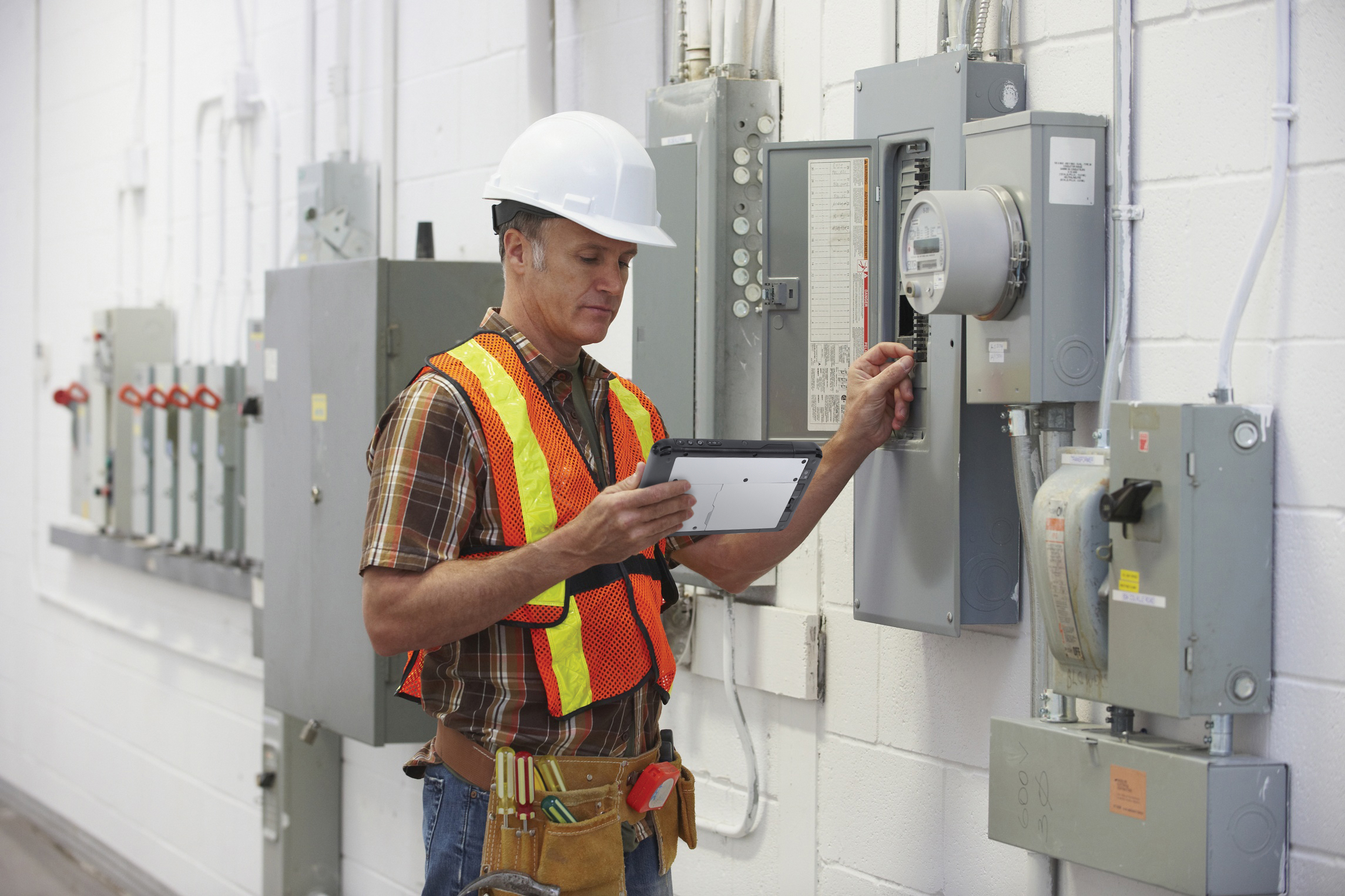 A photo of an electrician inspecting an electricity box