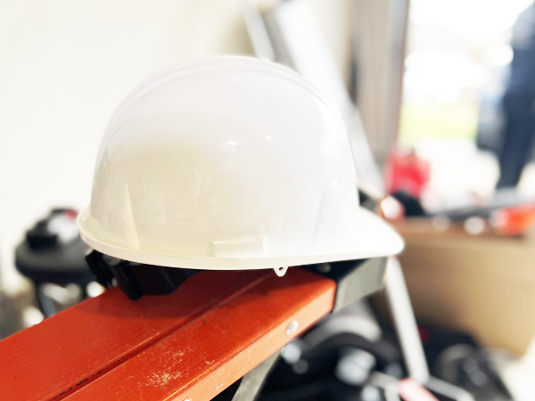 A photo of a white hard-hat on a red metal bench
